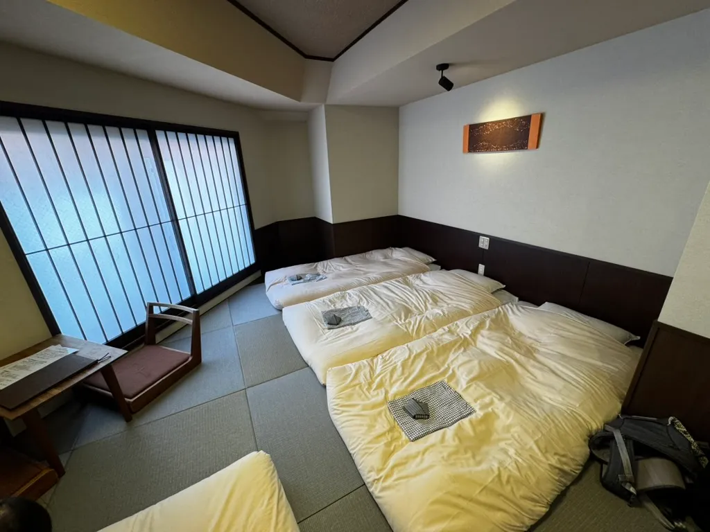 501号室のモダン和室に4組の布団が並べて敷かれている